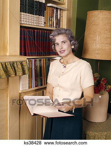 1960s smiling middle aged woman reading holding open book View Large Photo Image Stock Photo - 1960s smiling middle aged woman reading holding open book. Fotosearch