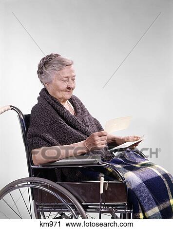 1960s smiling senior woman sitting in wheelchair reading letter View Large Photo Image Stock Image - 1960s smiling senior woman sitting in wheelchair reading letter. Fotosearch