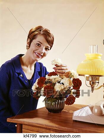 1960s smiling woman arranging vase red white carnations View Large Photo Image Stock Photo - 1960s smiling woman arranging vase red white carnations. Fotosearch