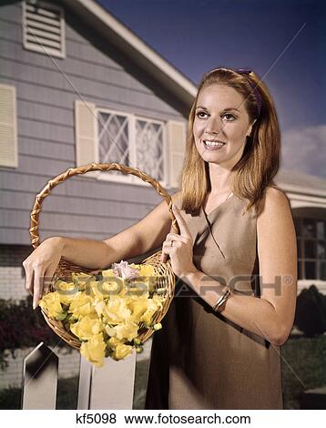 1960s smiling woman basket yellow flowers house background View Large Photo Image Stock Photo - 1960s smiling woman basket yellow flowers house background. Fotosearch