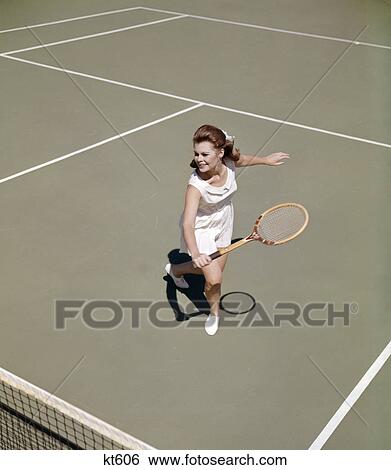 1960s smiling woman playing tennis swinging racket to hit ball action recreation exercise View Large Photo Image Stock Photograph - 1960s smiling woman playing tennis swinging racket to hit ball action recreation exercise. Fotosearch
