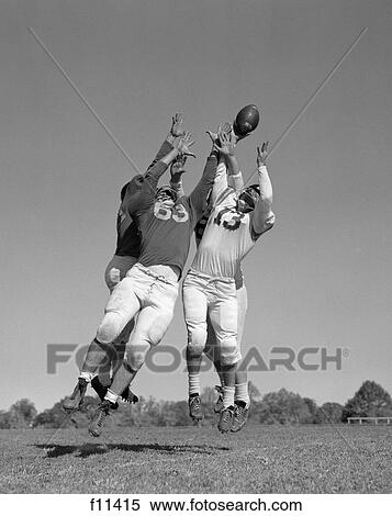 1960s three football players reaching to catch ball View Large Photo Image Stock Photography - 1960s three football players reaching to catch ball. Fotosearch