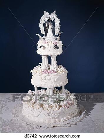 Stock Image - 1960s three tier ornately decorated wedding cake. Fotosearch