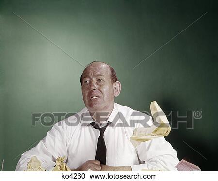 1960s tired overworked businessman at desk shirtsleeves loose tie paper floating funny expression View Large Photo Image Stock Image - 1960s tired overworked businessman at desk shirtsleeves loose tie paper floating funny expression. Fotosearch