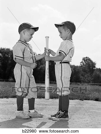 1960s two boys in baseball uniforms choosing sides by getting the upper hand View Large Photo Image Stock Image - 1960s two boys in baseball uniforms choosing sides by getting the upper hand. Fotosearch