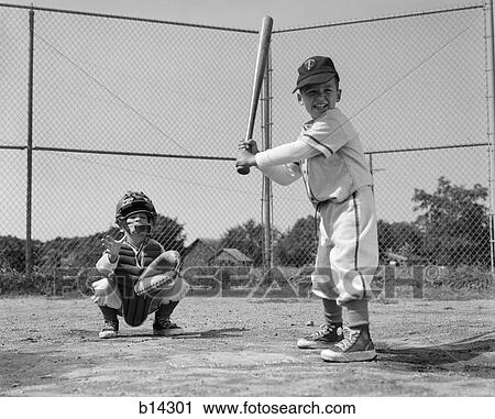Stock Image - 1960s two boys playing baseball batter and catcher at home plate. Fotosearch
