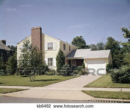 1960s two story yellow house white shutters garage brick chimney suburban neighborhood View Large Photo Image Stock Image - 1960s two story yellow house white shutters garage brick chimney suburban neighborhood. Fotosearch