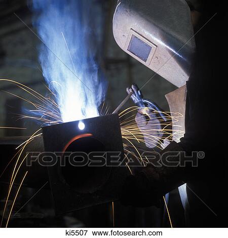 1960s welder wearing protective face mask welding with blue flame and sparks View Large Photo Image Stock Photo - 1960s welder wearing protective face mask welding with blue flame and sparks. Fotosearch