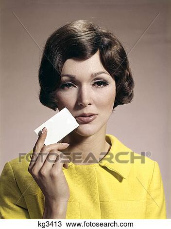 1960s woman holding blank business card to face View Large Photo Image Stock Image - 1960s woman holding blank business card to face. Fotosearch