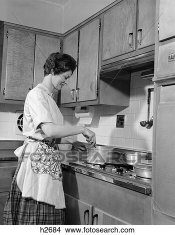 1960s woman kitchen cooking stove pot stir View Large Photo Image Picture - 1960s woman kitchen cooking stove pot stir. Fotosearch