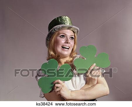 1960s woman smiling holding green shamrocks wearing green party hat for saint patrick's day View Large Photo Image Picture - 1960s woman smiling holding green shamrocks wearing green party hat for saint patrick's day. Fotosearch