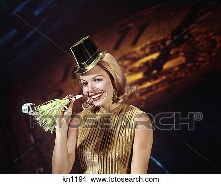 1960s young blond woman party hat noisemaker horn smiling new year clock background View Large Photo Image Picture - 1960s young blond woman party hat noisemaker horn smiling new year clock background. Fotosearch