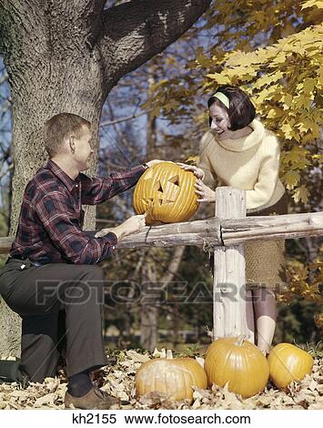 1960s young couple man woman in autumn woods carving halloween jack-o-lantern pumpkin View Large Photo Image Stock Photography - 1960s young couple man woman in autumn woods carving halloween jack-o-lantern pumpkin. Fotosearch