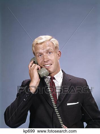 1960s young smiling blond businessman salesman talking on telephone View Large Photo Image Stock Photo - 1960s young smiling blond businessman salesman talking on telephone. Fotosearch