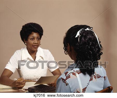 1970s african american adult woman interviewing teenage girl View Large Photo Image Stock Photograph - 1970s african american adult woman interviewing teenage girl. Fotosearch
