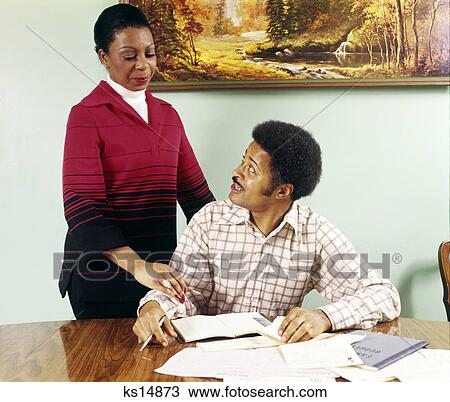 1970s african american couple man woman at table going over household accounts View Large Photo Image Stock Image - 1970s african american couple man woman at table going over household accounts. Fotosearch