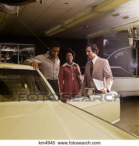 1970s african american couple with caucasian salesman automobile showroom new car purchase View Large Photo Image Stock Photography - 1970s african american couple with caucasian salesman automobile showroom new car purchase. Fotosearch