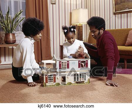 1970s african american family mother father daughter playing on living room floor with doll house View Large Photo Image Stock Image - 1970s african american family mother father daughter playing on living room floor with doll house. Fotosearch