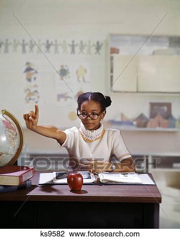 1970s african american girl role playing teacher holding up hand asking for answer to question in elementary school classroom View Large Photo Image Stock Image - 1970s african american girl role playing teacher holding up hand asking for answer to question in elementary school classroom. Fotosearch