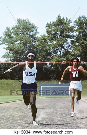 1970s african american man athlete breaking tape at finish line winning the race View Large Photo Image Picture - 1970s african american man athlete breaking tape at finish line winning the race. Fotosearch
