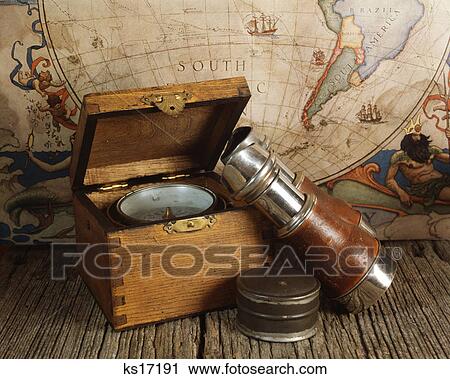 Stock Image - 1970s antique world map binoculars compass nautical still life. Fotosearch