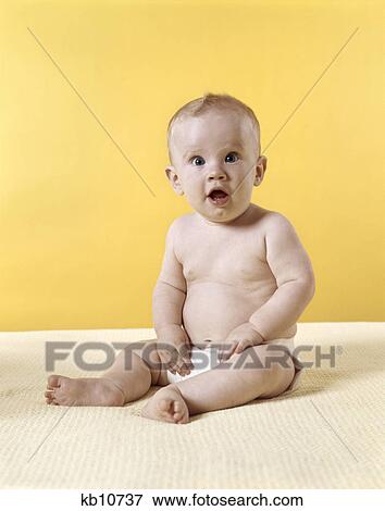 1970s baby wearing diaper sitting on blanket yellow background View Large Photo Image Stock Photo - 1970s baby wearing diaper sitting on blanket yellow background. Fotosearch