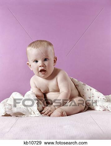 1970s blond baby sitting with blanket wrapped around back pink background View Large Photo Image Stock Photo - 1970s blond baby sitting with blanket wrapped around back pink background. Fotosearch
