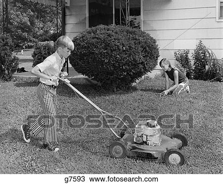1970s boy chores mowing lawn cutting grass yard work View Large Photo Image Stock Image - 1970s boy chores mowing lawn cutting grass yard work. Fotosearch