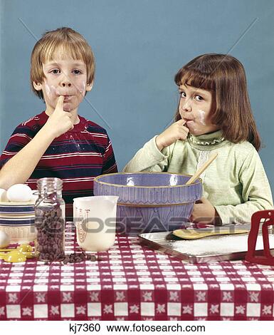 1970s boy girl brother sister making cookies tasting batter chocolate chips baking cooking View Large Photo Image Stock Image - 1970s boy girl brother sister making cookies tasting batter chocolate chips baking cooking. Fotosearch