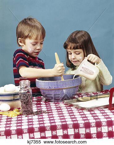 1970s boy girl brother sister making cookies stirring batter chocolate chips baking cooking View Large Photo Image Stock Photography - 1970s boy girl brother sister making cookies stirring batter chocolate chips baking cooking. Fotosearch