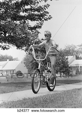 1970s boy riding bike suburban sidewalk View Large Photo Image Stock Photo - 1970s boy riding bike suburban sidewalk. Fotosearch