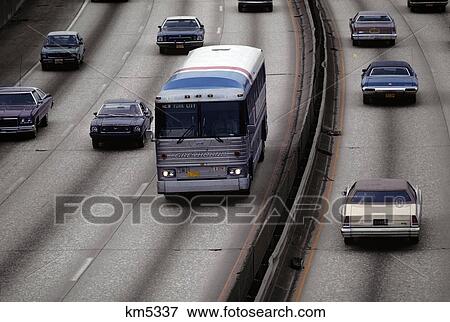 Stock Photo - 1970s cars and bus on divided multi-lane highway. Fotosearch