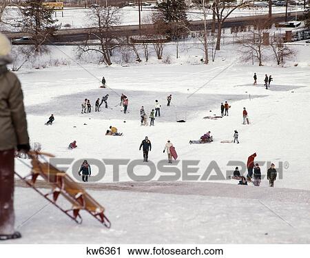 1970s children playing hockey on frozen pond nearby children families sledding snow winter recreation View Large Photo Image Stock Image - 1970s children playing hockey on frozen pond nearby children families sledding snow winter recreation. Fotosearch