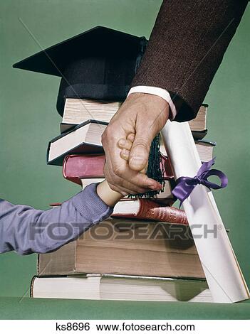 1970s composite image stack books boy adult father hands graduation cap diploma mortarboard View Large Photo Image Stock Photograph - 1970s composite image stack books boy adult father hands graduation cap diploma mortarboard. Fotosearch