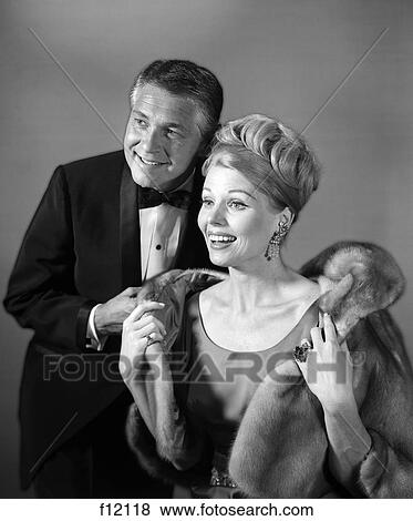 1970s couple in evening wear man in tuxedo woman in fur coat View Large Photo Image Stock Photo - 1970s couple in evening wear man in tuxedo woman in fur coat. Fotosearch
