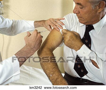 1970s doctor giving injection to senior man View Large Photo Image Stock Image - 1970s doctor giving injection to senior man. Fotosearch