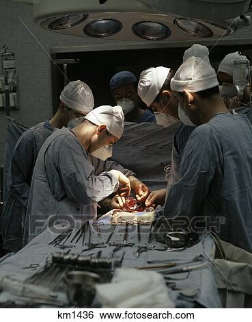 1970s doctors performing surgery in operating room View Large Photo Image Stock Photograph - 1970s doctors performing surgery in operating room. Fotosearch