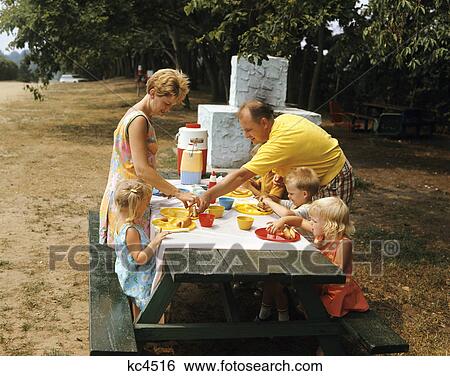 1970s family eating at outdoor picnic table View Large Photo Image Stock Photograph - 1970s family eating at outdoor picnic table. Fotosearch