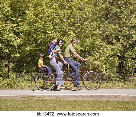 1970s family four tandem bicycle mother father kids boy backseat baby backpack wearing bellbottom jeans View Large Photo Image Stock Image - 1970s family four tandem bicycle mother father kids boy backseat baby backpack wearing bellbottom jeans. Fotosearch