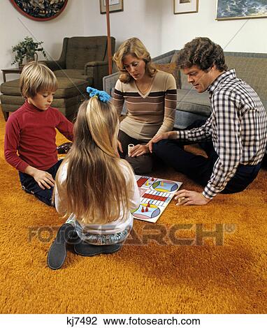 1970s family playing parcheesi on living room floor with bright orange shag carpeting View Large Photo Image Stock Image - 1970s family playing parcheesi on living room floor with bright orange shag carpeting. Fotosearch