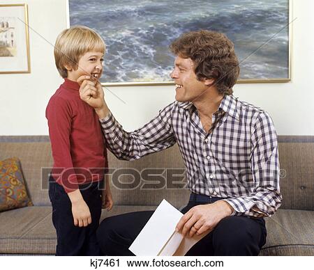 1970s father and son laughing talking touching couch man boy View Large Photo Image Stock Image - 1970s father and son laughing talking touching couch man boy. Fotosearch