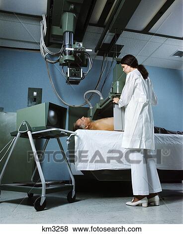 1970s female x-ray technician working with senior male patient man woman View Large Photo Image Stock Photo - 1970s female x-ray technician working with senior male patient man woman. Fotosearch