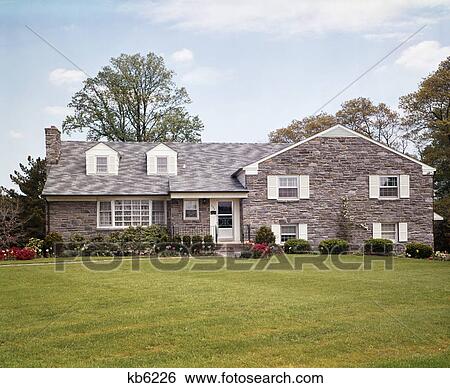 1970s front view of a two story flagstone house with white shutters View Large Photo Image Stock Photograph - 1970s front view of a two story flagstone house with white shutters. Fotosearch
