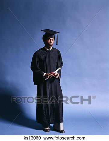 1970s full length portrait african american young man school graduate black cap gown holding diploma View Large Photo Image Stock Image - 1970s full length portrait african american young man school graduate black cap gown holding diploma. Fotosearch