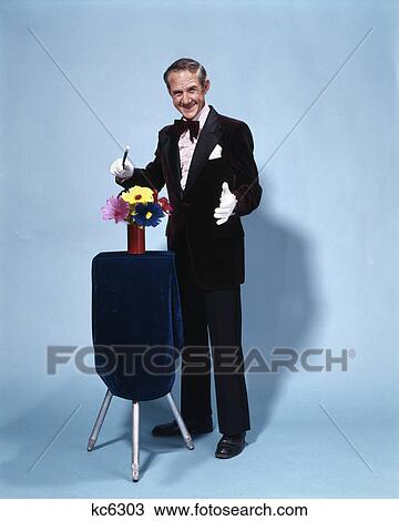 1970s full length smiling magician waving wand over flowers View Large Photo Image Stock Image - 1970s full length smiling magician waving wand over flowers. Fotosearch