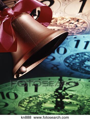 1970s golden bell with red bow ringing in the new year against background of clock faces showing midnight View Large Photo Image Stock Photo - 1970s golden bell with red bow ringing in the new year against background of clock faces showing midnight. Fotosearch