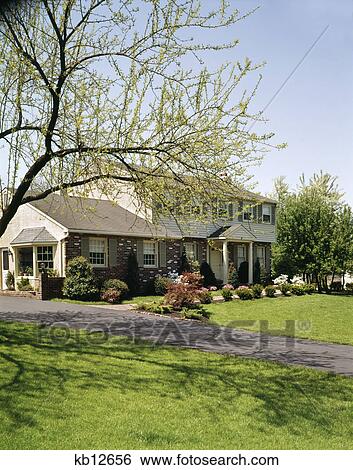 1970s house with brick siding and beige shutters in the springtime View Large Photo Image Stock Photograph - 1970s house with brick siding and beige shutters in the springtime. Fotosearch