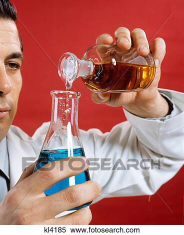 1970s lab worker man pouring liquid from bottle into flask View Large Photo Image Stock Photography - 1970s lab worker man pouring liquid from bottle into flask. Fotosearch