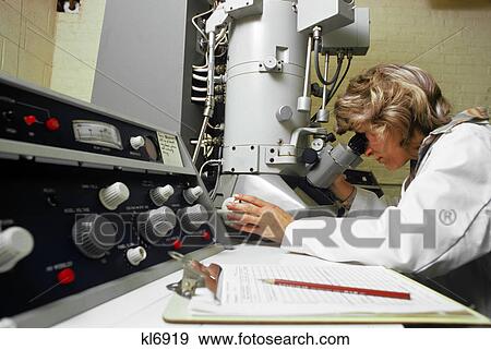 Stock Photo - 1970s laboratory woman technician using electron microscope. Fotosearch