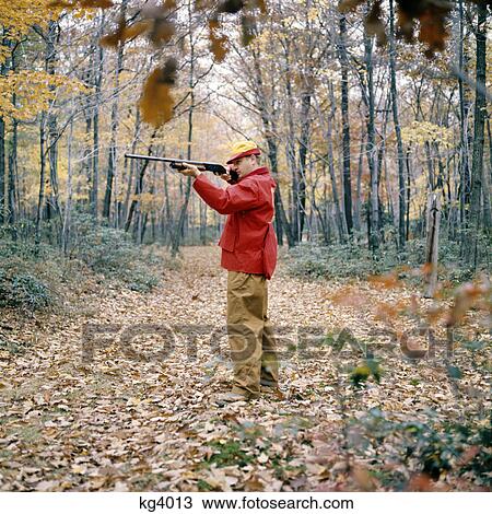 1970s man hunting in autumn woods pointing shotgun View Large Photo Image Stock Image - 1970s man hunting in autumn woods pointing shotgun. Fotosearch